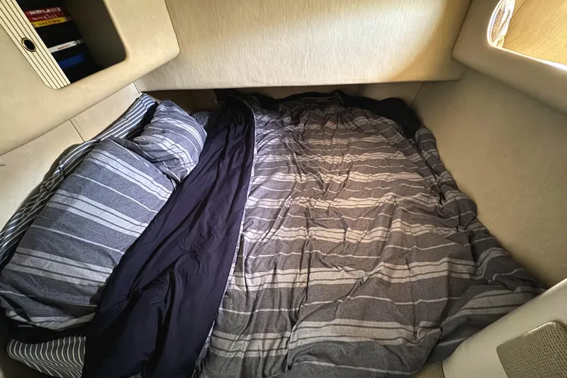 Slide: The Image of Cozy cabin bed in 1996 Sea Ray 400 Sedan Bridge with striped bedding. - 45