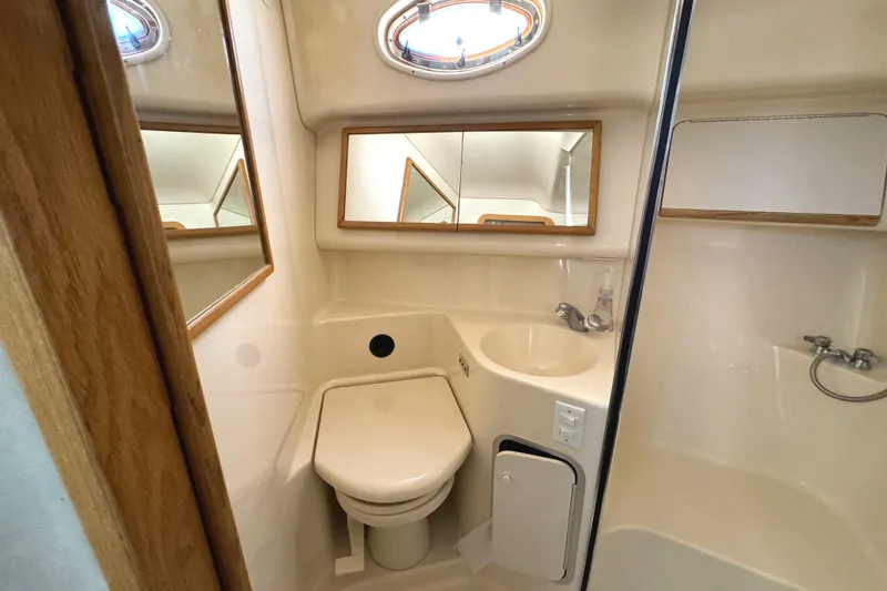 Slide: The Image of Bathroom interior of 1996 Sea Ray 400 Sedan Bridge yacht, featuring toilet and sink. - 48