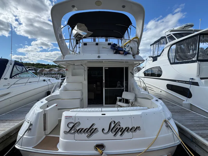 Slide: The Image of 1996 Sea Ray 400 Sedan Bridge yacht docked, rear view with "Lady Slipper" name visible. - 8