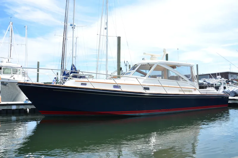The Image of 2003 Little Harbor WhisperJet 38 docked in a marina under a clear sky. - 0