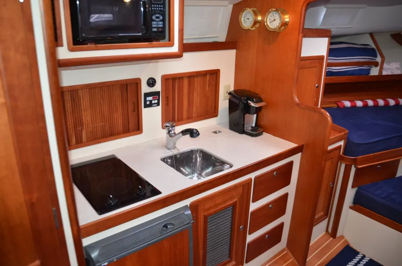 Slide: The Image of 2003 Little Harbor WhisperJet 38 interior with kitchenette, sink, stove, and cozy seating area. - 17