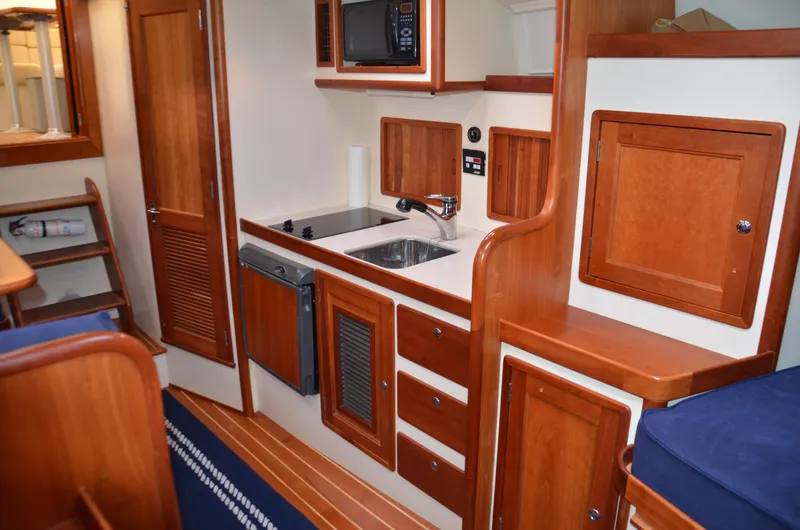 Slide: The Image of 2003 Little Harbor WhisperJet 38 cabin with blue cushions and wooden interior. - 19