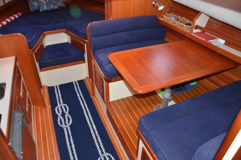 Slide: The Image of Interior of 2003 Little Harbor WhisperJet 38 with wooden table, blue seating, and nautical decor. - 20