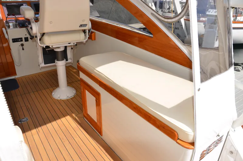 Slide: The Image of 2003 Little Harbor WhisperJet 38 boat with wooden deck and striped seating at a marina. - 6