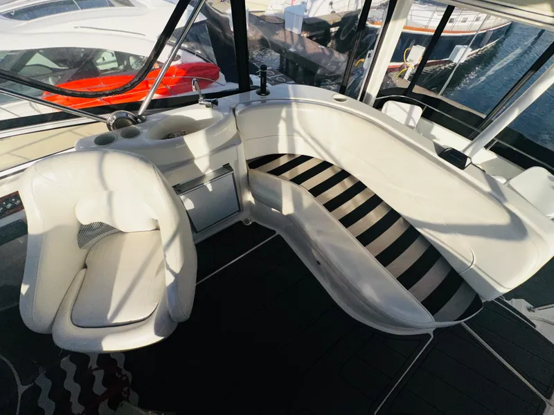 Slide: The Image of 2005 Meridian 368 Motor Yacht interior with white seating and helm, docked at marina. - 10