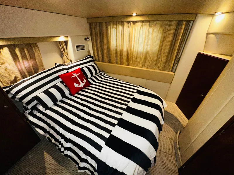 Slide: The Image of Luxurious bedroom in 2005 Meridian 368 Motor Yacht with striped bedding and anchor pillow. - 17