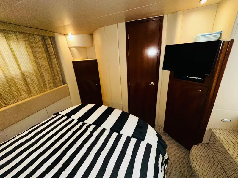 Slide: The Image of Interior of 2005 Meridian 368 Motor Yacht bedroom with striped bedding and TV. - 18