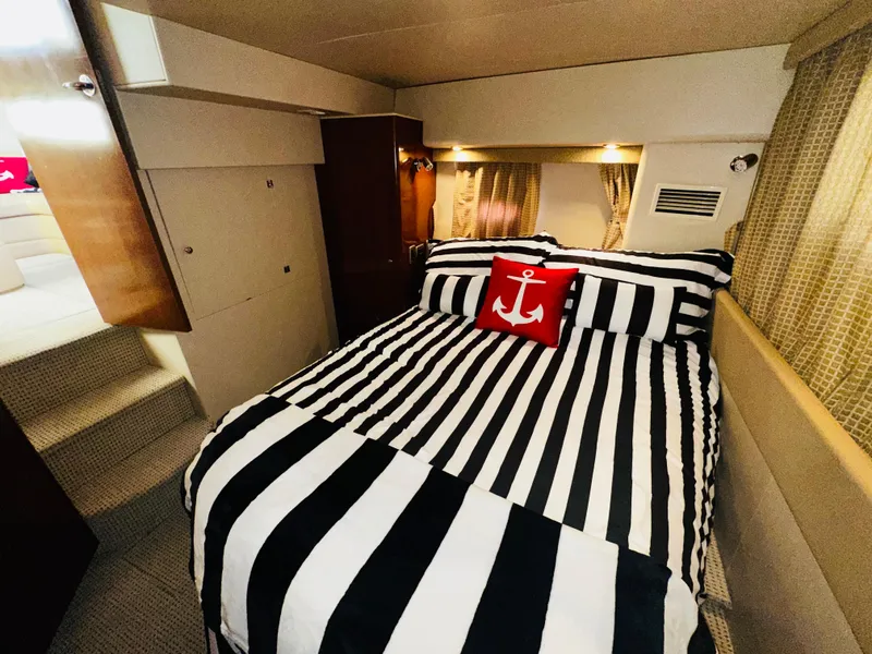 Slide: The Image of Luxurious bedroom in 2005 Meridian 368 Motor Yacht with striped bedding and anchor pillow. - 20
