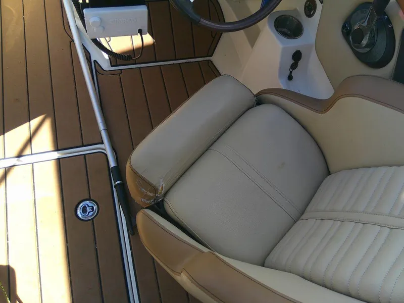 Slide: The Image of 2018 Sea Ray SPX 230 boat interior with tan seating and wood flooring. - 9