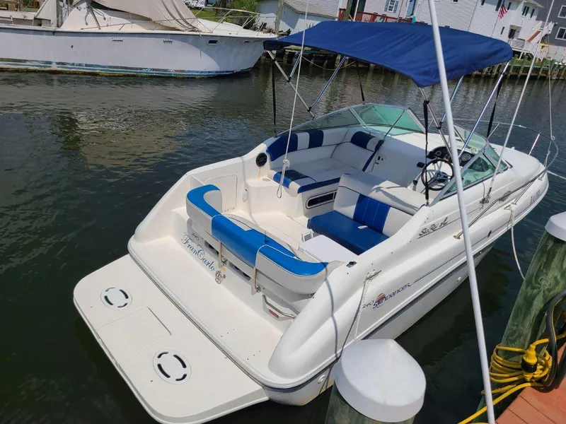 The Image of 1996 Sea Ray 240 Sundancer boat docked, featuring blue and white seating and a canopy. - 0