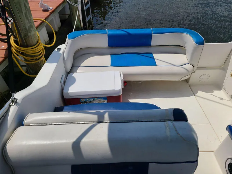 Slide: The Image of 1996 Sea Ray 240 Sundancer boat interior with blue and white seating and a cooler. - 3