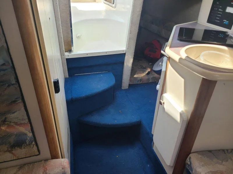 Slide: The Image of Interior of a 1996 Sea Ray 240 Sundancer boat with blue carpeted steps. - 5