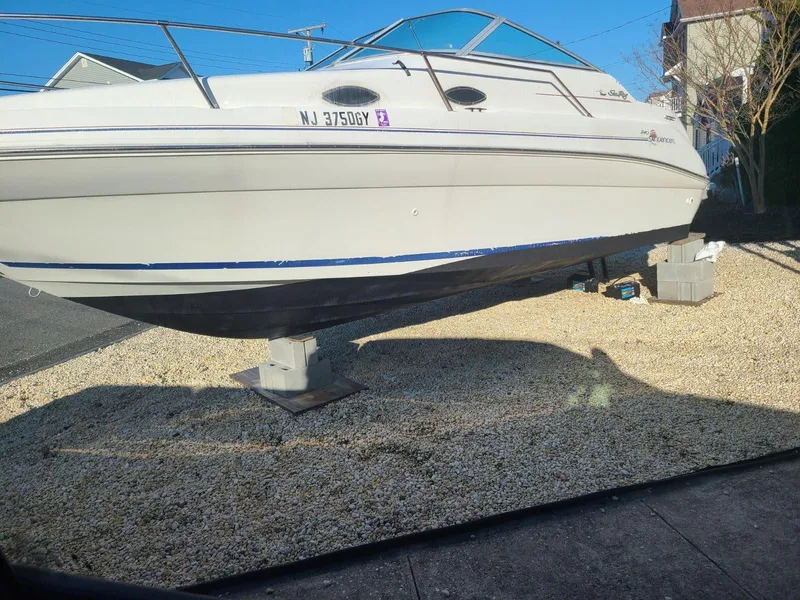 Slide: The Image of 1996 Sea Ray 240 Sundancer boat on dry dock, displayed on gravel surface. - 7