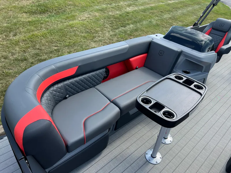 Slide: The Image of 2025 Godfrey SWEETWATER 2286 SFL boat interior with gray and red seating, cupholders, and table. - 11