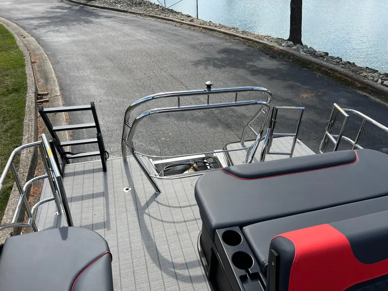 Slide: The Image of 2025 Godfrey SWEETWATER 2286 SFL boat interior with seating and railing near water. - 18