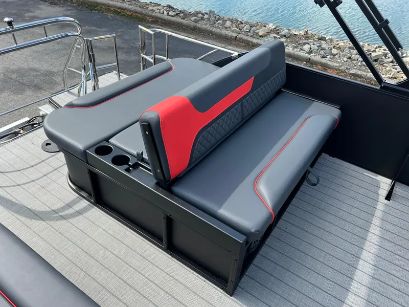 Slide: The Image of 2025 Godfrey SWEETWATER 2286 SFL boat seating with red and gray upholstery by the water. - 19