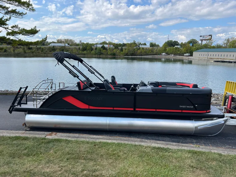 Slide: The Image of 2025 Godfrey SWEETWATER 2286 SFL pontoon boat by a serene lake. - 3