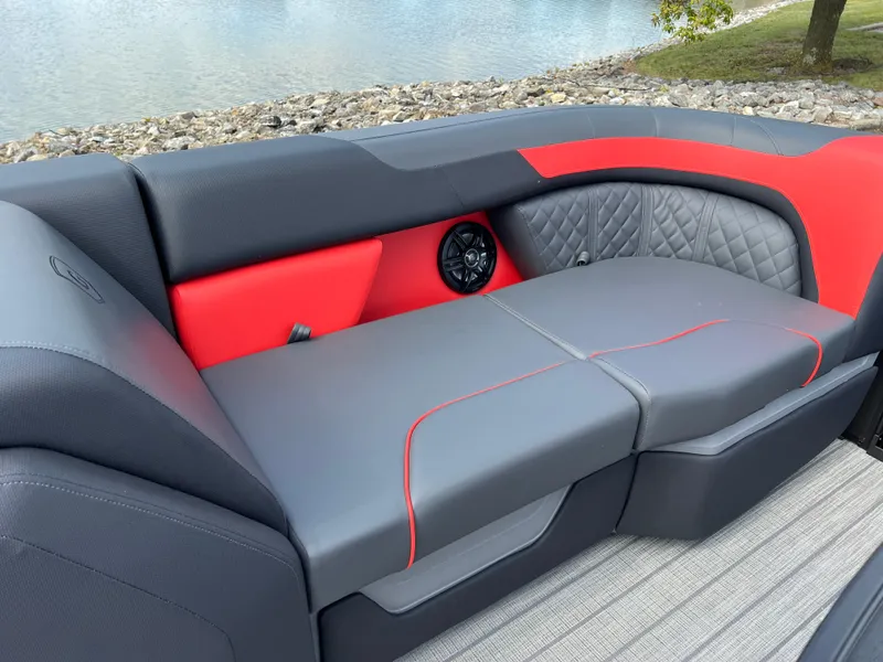 Slide: The Image of 2025 Godfrey SWEETWATER 2286 SFL boat seating with red and gray upholstery by the water. - 34