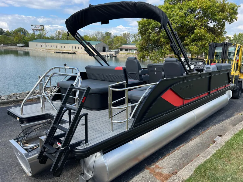 Slide: The Image of 2025 Godfrey SWEETWATER 2286 SFL pontoon boat docked by a serene lake. - 5