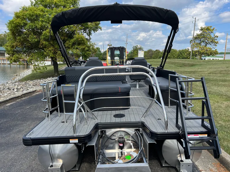 Slide: The Image of 2025 Godfrey SWEETWATER 2286 SFL pontoon boat, rear view, docked near a lake. - 6