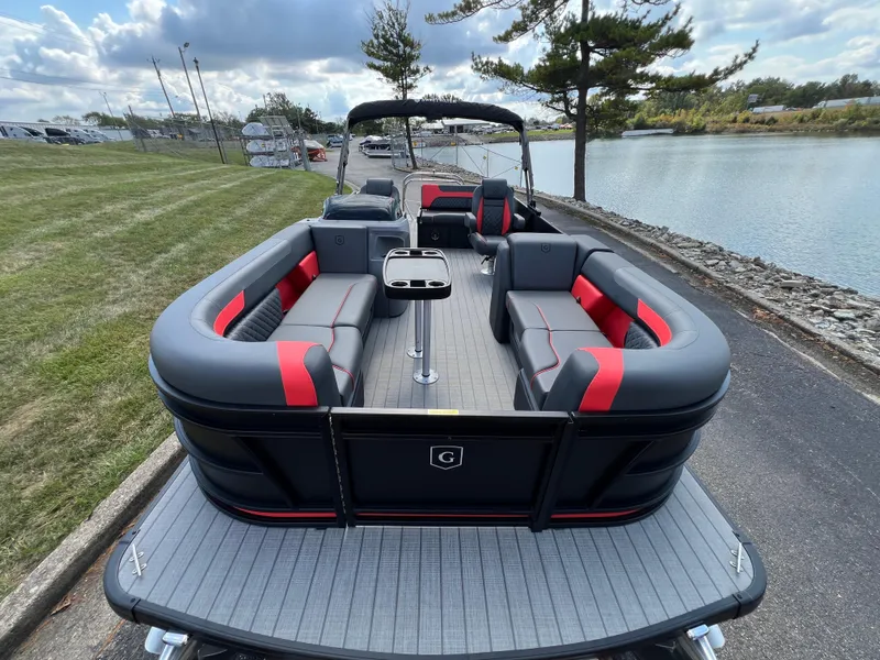 Slide: The Image of 2025 Godfrey SWEETWATER 2286 SFL pontoon boat with sleek seating by a serene lake. - 9