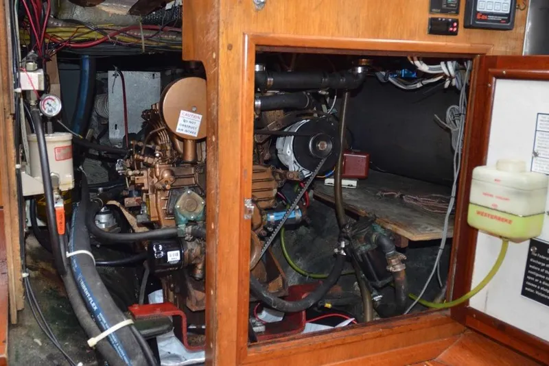 Slide: The Image of Engine compartment of a 1971 Hinckley Bermuda 40 sailboat, showcasing mechanical components and wiring. - 14