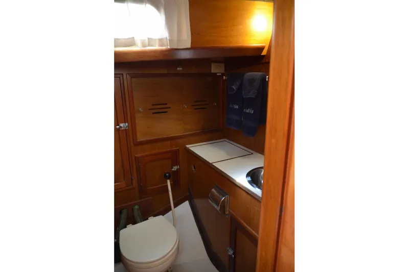 Slide: The Image of 1971 Hinckley Bermuda 40 yacht interior with wooden cabinetry and compact bathroom. - 11