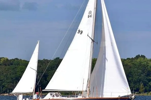 Slide: The Image of 1971 Hinckley Bermuda 40 sailboat with white sails on a calm lake. - 17