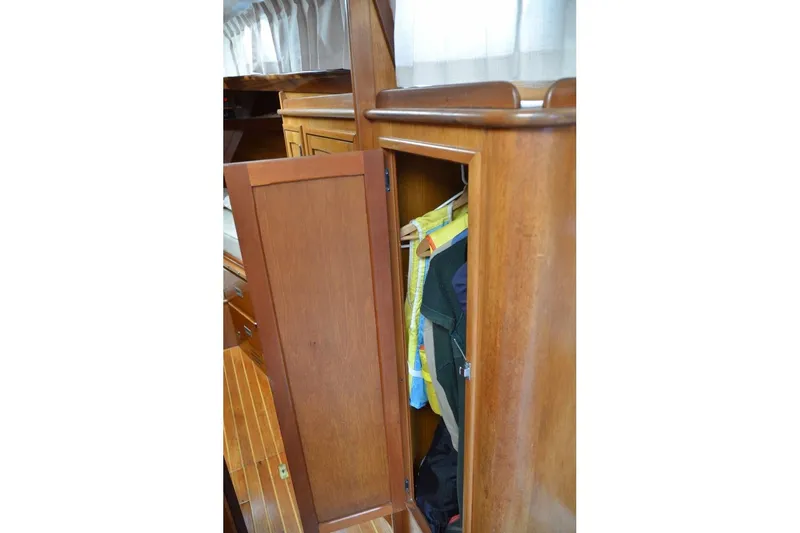 Slide: The Image of Wooden closet interior on 1971 Hinckley Bermuda 40 yacht, showcasing hanging clothes. - 8