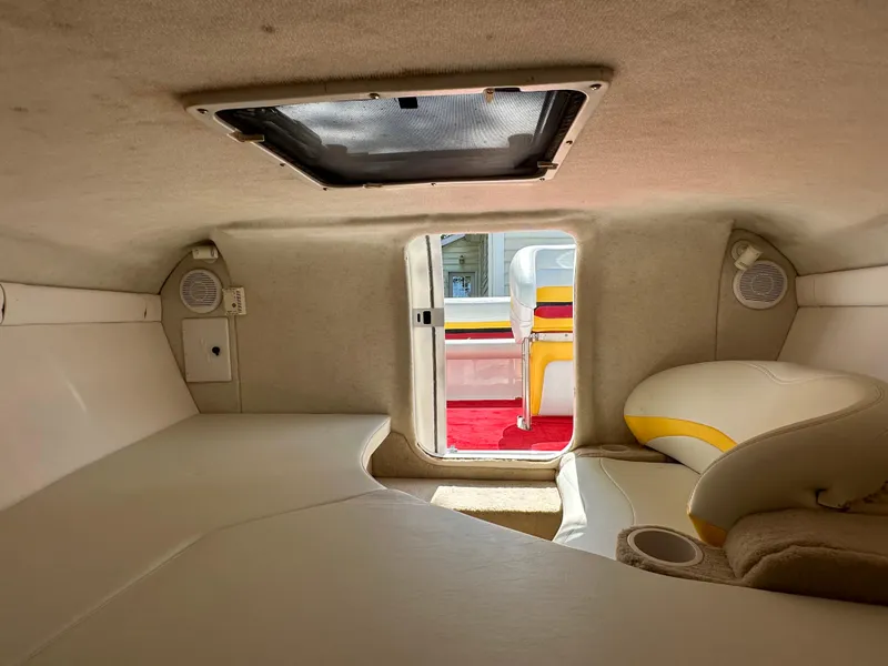 Slide: The Image of Interior cabin of a 2001 Baja 232 boat, featuring seating and a hatch. - 13