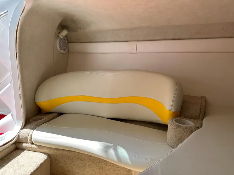 Slide: The Image of Interior of a 2001 Baja 232 boat featuring beige and yellow seating. - 14