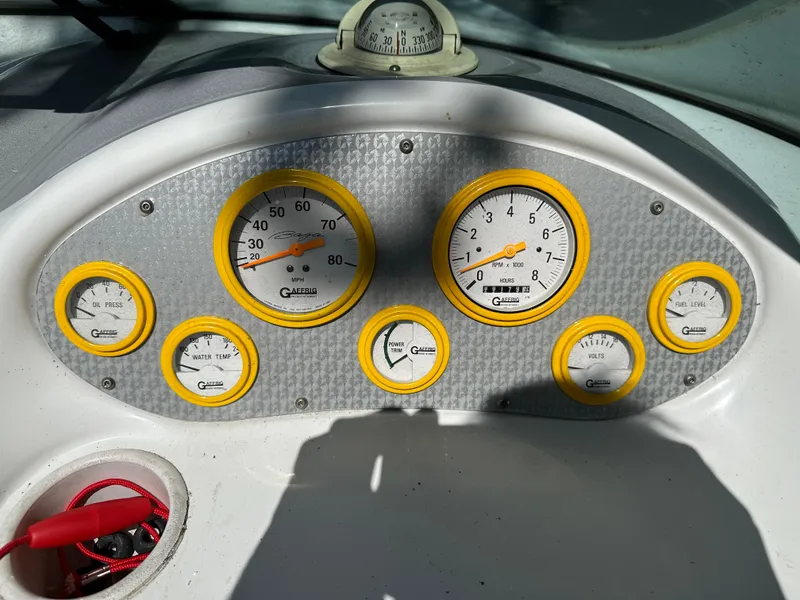 Slide: The Image of Dashboard of a 2001 Baja 232 boat with yellow-rimmed gauges. - 15