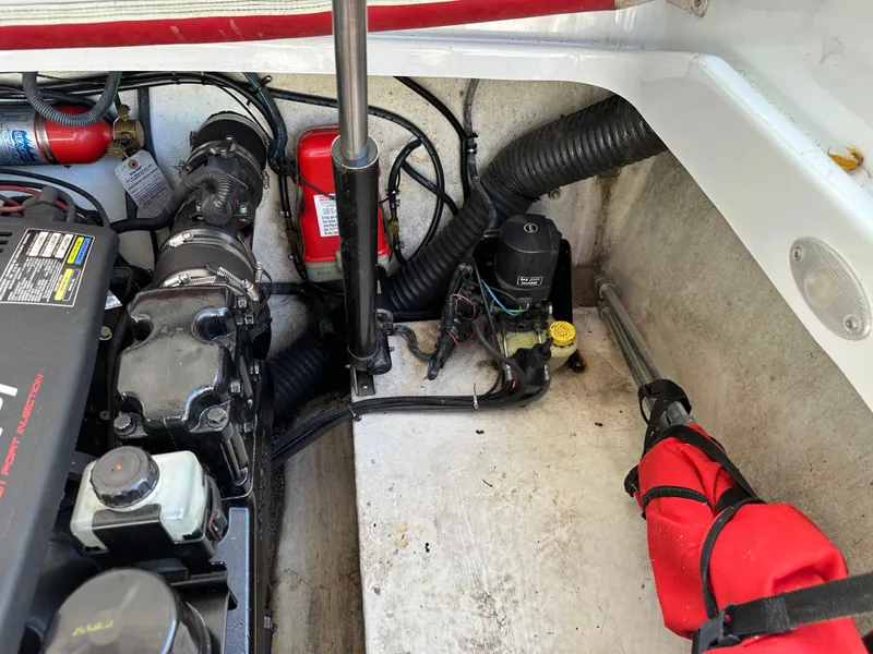 Slide: The Image of Engine compartment of a 2001 Baja 232 boat, featuring mechanical components and safety equipment. - 19