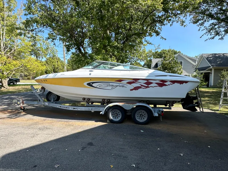 Slide: The Image of 2001 Baja 232 speedboat on trailer, parked outdoors, with vibrant graphics and clear blue sky. - 24