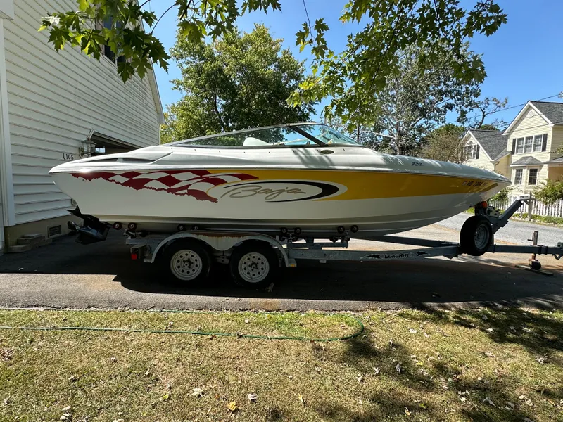 Slide: The Image of 2001 Baja 232 speedboat on trailer, parked in driveway, surrounded by trees and houses. - 27