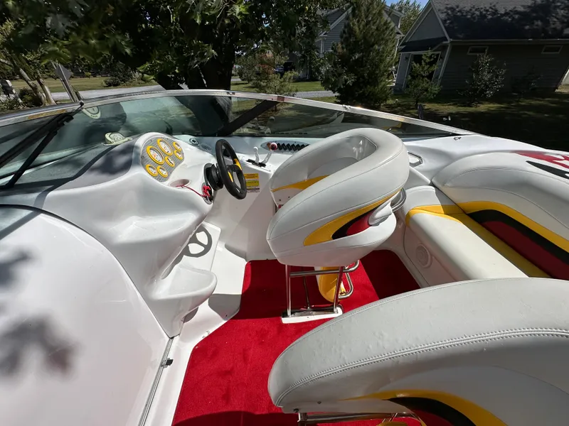 Slide: The Image of 2001 Baja 232 boat interior with white seats, red carpet, and dashboard controls. - 7
