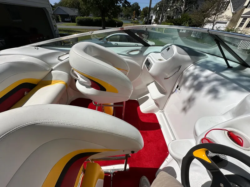 Slide: The Image of 2001 Baja 232 boat interior with white and yellow seats, red carpet, and steering wheel. - 8