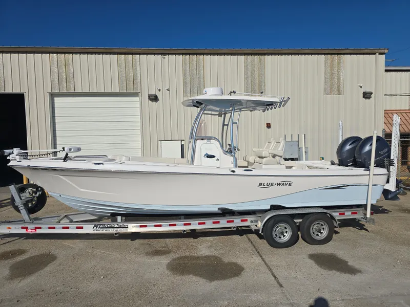 Slide: The Image of 2021 Blue Wave 2800 Makaira boat on trailer, parked outside a warehouse. - 2