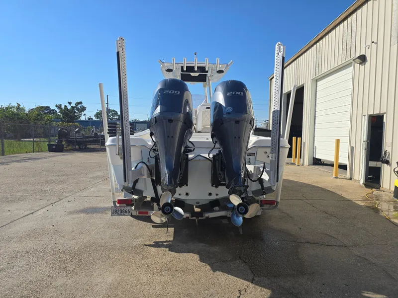 Slide: The Image of 2021 Blue Wave 2800 Makaira boat with dual outboard engines, parked outdoors. - 4