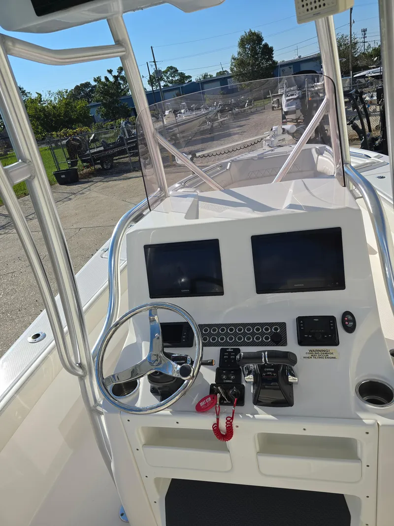 Slide: The Image of 2021 Blue Wave 2800 Makaira boat dashboard with dual screens and steering wheel. - 8