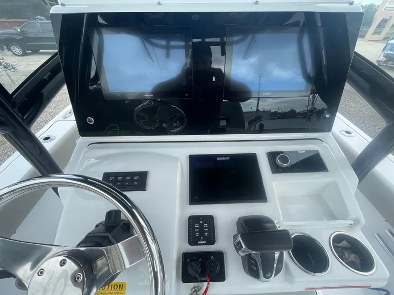 Slide: The Image of 2022 Sportsman Masters 267OE Bay Boat dashboard with steering wheel and electronic controls. - 15