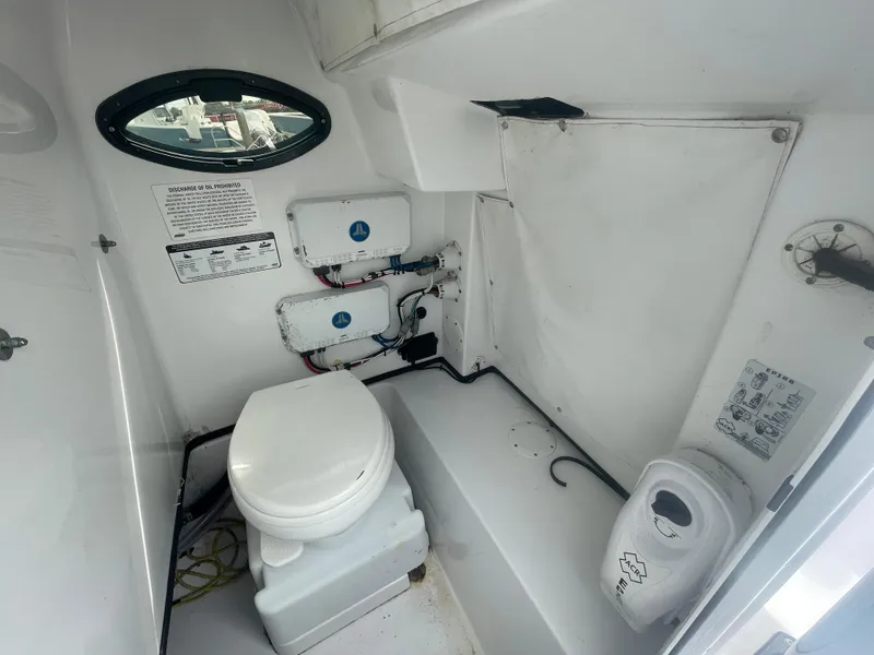 Slide: The Image of 2022 Sportsman Masters 267OE Bay Boat interior with marine toilet and storage. - 20