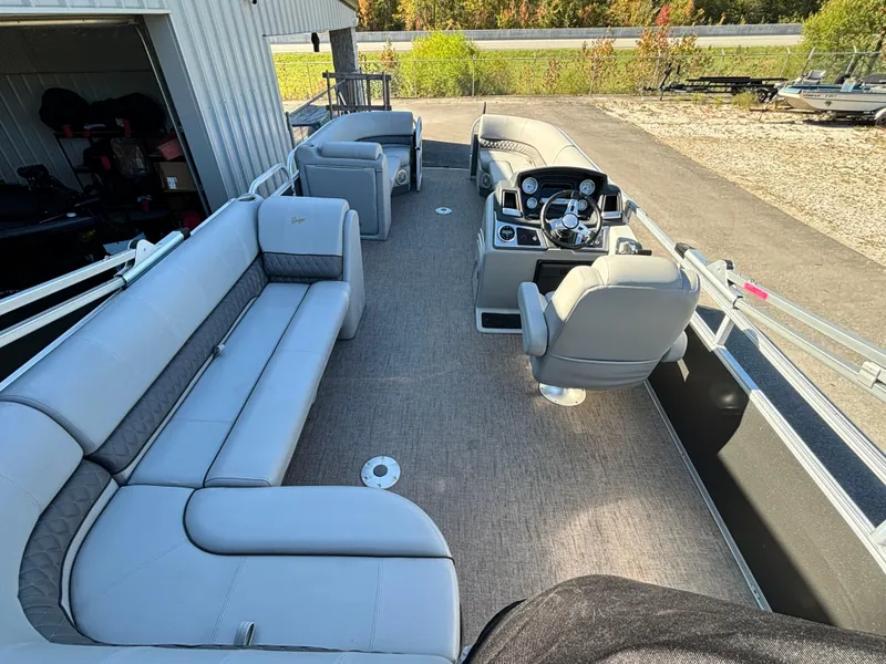Slide: The Image of 2023 Ranger Reata 220C pontoon boat interior with gray seating and steering console. - 10
