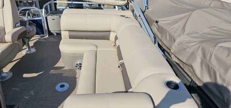Slide: The Image of 2023 Sun Tracker Fishin' Barge 20 DLX interior with beige seating and cup holders. - 6