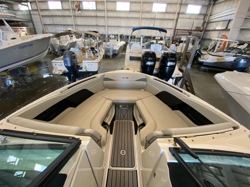 Slide: The Image of 2025 Sea Ray SLX 260 Outboard in showroom, featuring luxurious seating and modern design. - 12