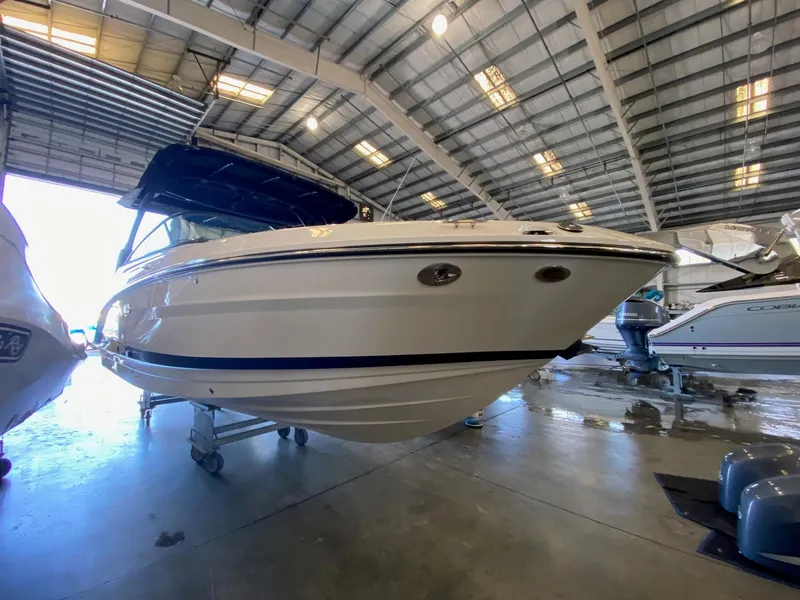 Slide: The Image of 2025 Sea Ray SLX 260 Outboard boat in a spacious indoor showroom. - 2