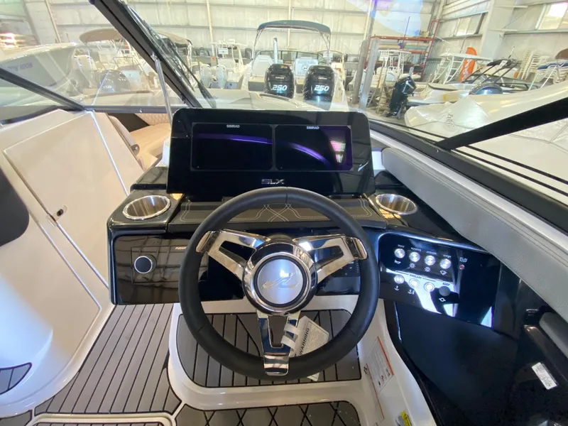 Slide: The Image of 2025 Sea Ray SLX 260 Outboard helm with modern controls and steering wheel. - 6