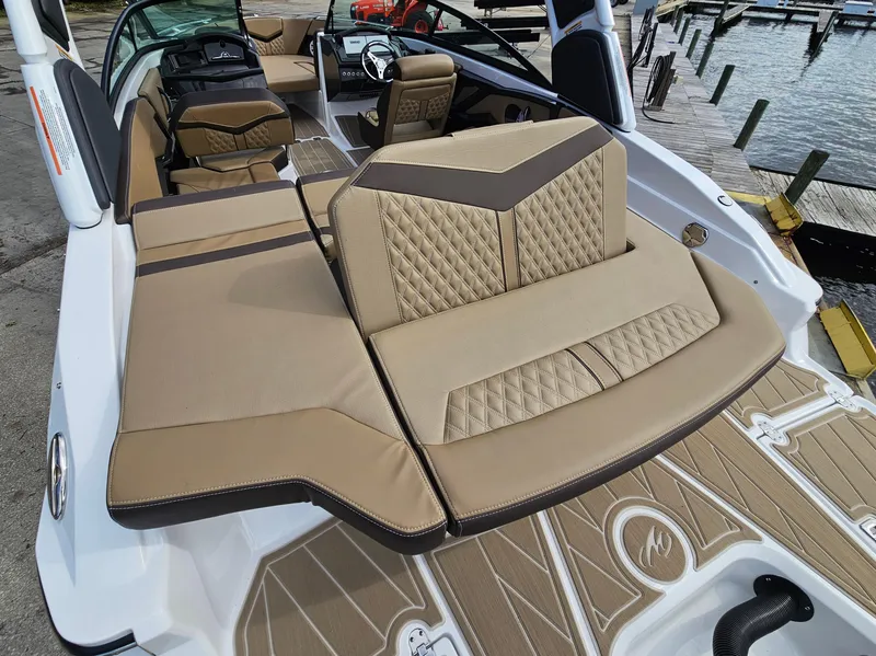 Slide: The Image of 2025 Monterey 235SS boat interior with tan upholstery and sleek design at a dock. - 14