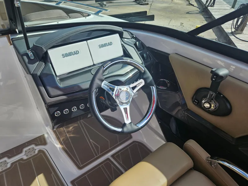 Slide: The Image of 2025 Monterey 235SS boat cockpit with steering wheel and Simrad displays. - 23