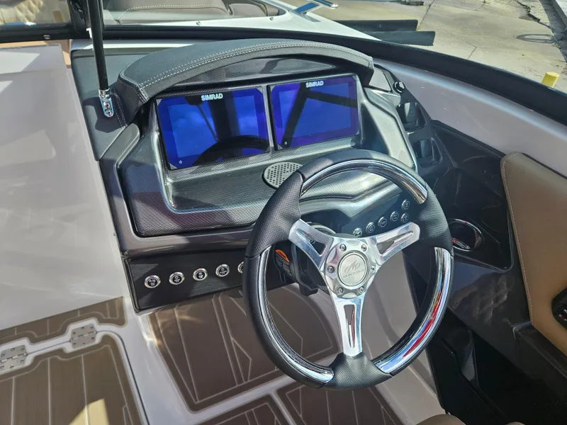 Slide: The Image of 2025 Monterey 235SS boat dashboard with dual Simrad displays and sleek steering wheel. - 24